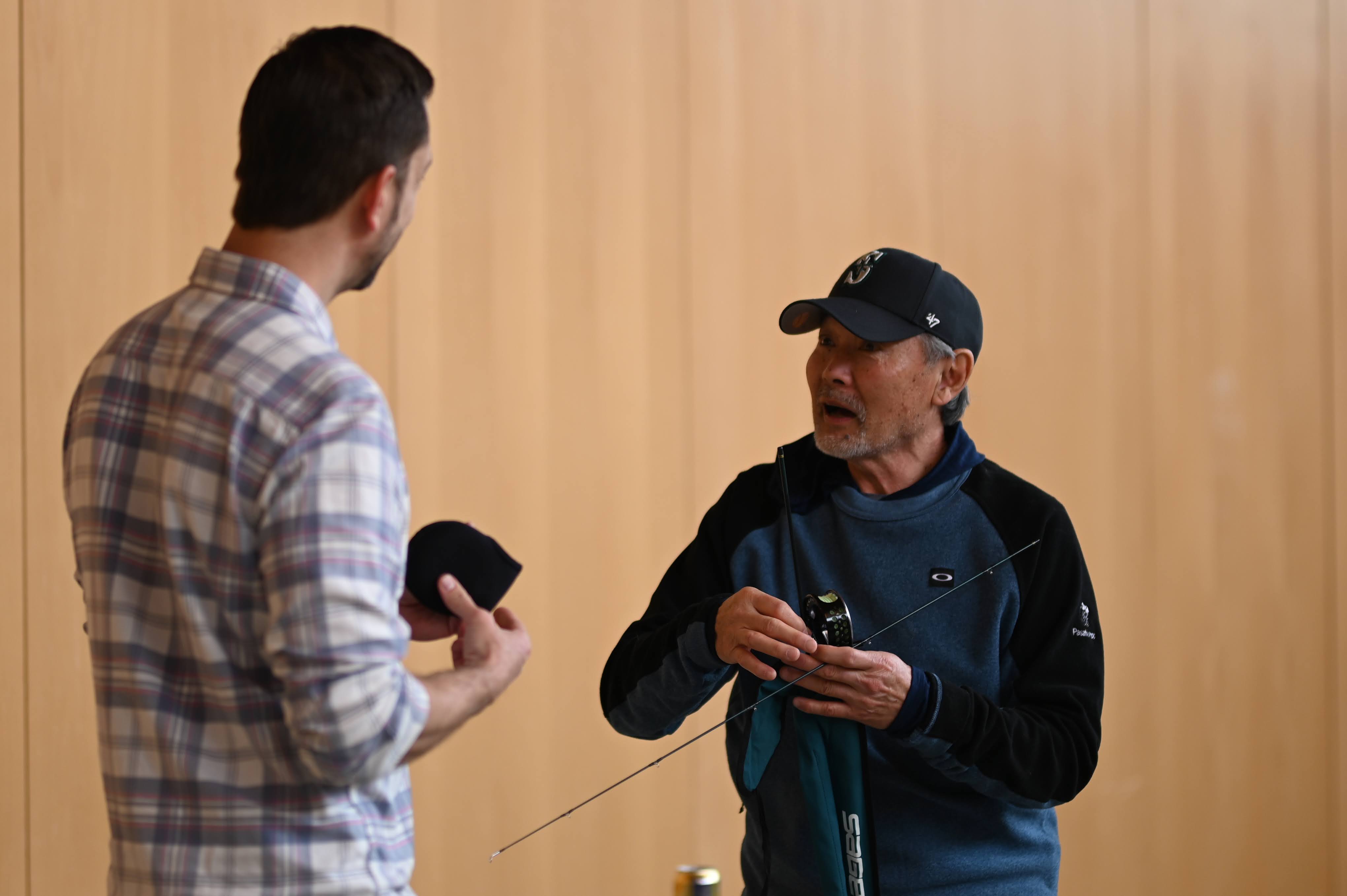 Experienced angler teaching fly fishing technique to another member
